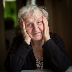 Russian grandmother. Portrait of an elderly woman sitting at a table in his house.