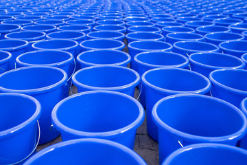 Hundreds of empty blue water bucket laid on the floor - save water save life festival