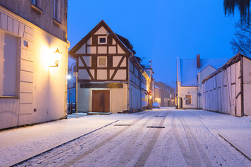 Narrow snowy street with half-timbered residential houses. Market street. Old town of Klaipeda city, Lithuania