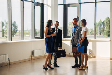 four business people handshake in office lobby