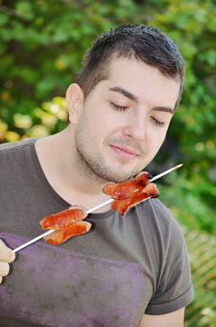 Handsome Young Man  Eating Sausages Outdoor