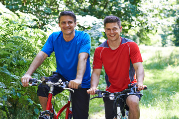 Two Men On Cycle Ride In Countryside Together