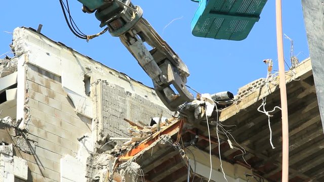 A demolition crane in action with a building. Find similar clips in our portfolio.