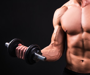 Fototapeta na wymiar muscular man doing exercises with dumbbell over grey