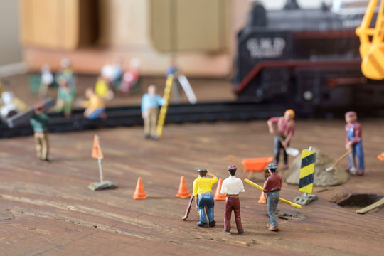 Construction toy / View of construction site of mini toy worker on wood background.