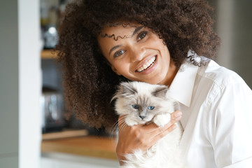 Portrait of mixed race woman cuddling cat