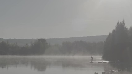 Homme observant le lac sur un ponton au canada