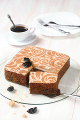Christmas Spicy Pudding with prunes and buttercream frosting, on white wooden background.