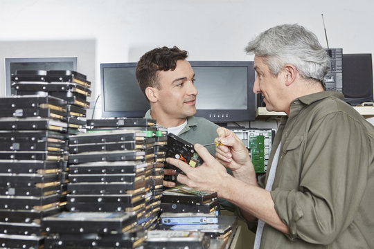 People working in storage of computer recycling plant