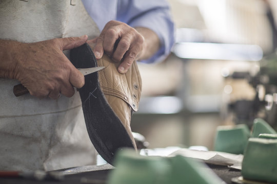 Shoemaker working on shoe in workshop