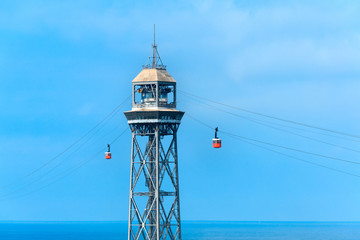 Red cable car over Barceloneta beach on blue sky background, Barcelona, Spain