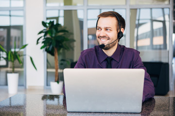smiling man with headset working as  call center operator