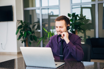 smiling man with headset working as  call center operator
