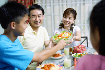 Mother passing food to family members