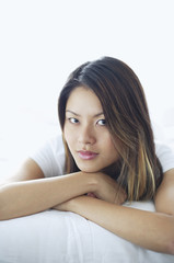Fototapeta premium Woman looking at camera, lying on front, arms crossed