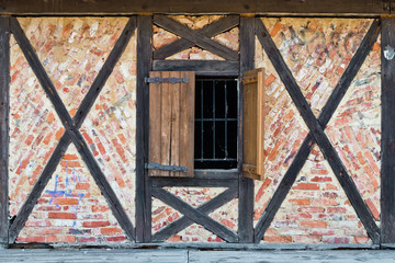 Old window in a brick wall with wooden beams