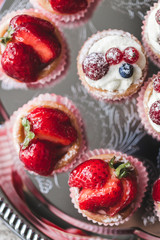 Delicious cupcakes with fresh strawberries, raspberries and blue