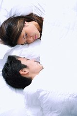 Fototapeta na wymiar Couple sleeping on bed