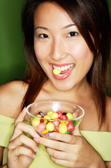 Woman eating candy and holding candy bowl