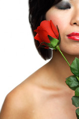 Woman holding rose, eyes closed