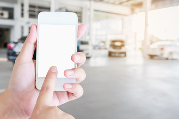 Woman using mobile smartphone with blur cars parking