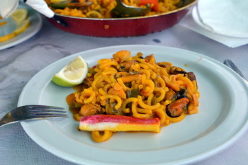 Noodle paella with seafood a bowl on a table.