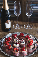 Delicious cupcakes and champagne for two on the vintage wooden t