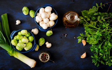 Dietary menu. Ingredients: Vegetables - Brussels sprouts, mushrooms, leeks and herbs on a dark background. Top view. Vegetables menu.