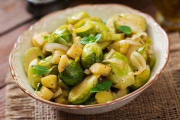 Stewed Brussels cabbage sprouts, apples and leeks in bowl. Dietary menu.