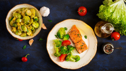 Baked fish salmon garnished with broccoli and tomato. Dietary menu. Fish menu. Seafood - salmon. Top view