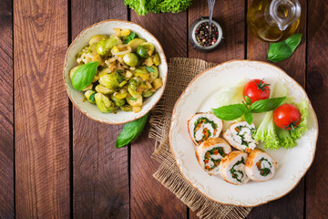 Chicken rolls with greens, garnished with salad. Top view