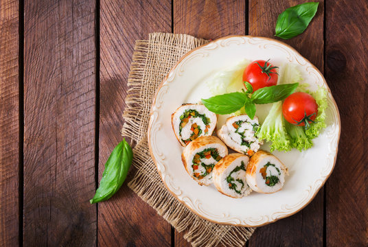 Chicken rolls with greens, garnished with salad. Top view