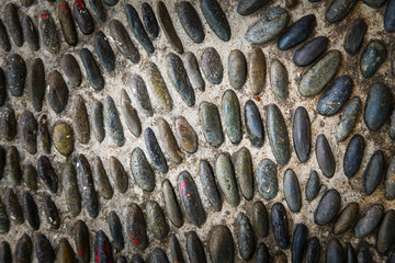 Round stones in the ground, Cobblestones in concrete background.