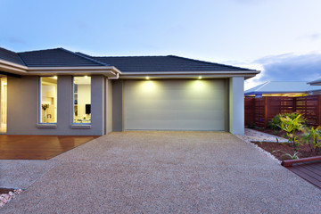 Garage with a long and wide concrete or stone yard in front at d