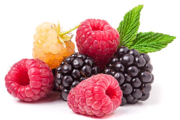 pile of raspberries and blackberries with leaves isolated on white background