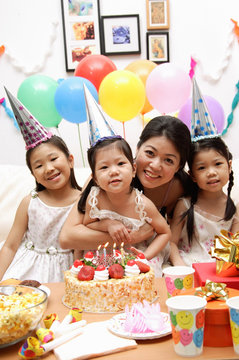 Mother with three girls celebrating a birthday