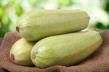 three courgettes on sackcloth with a blurred background