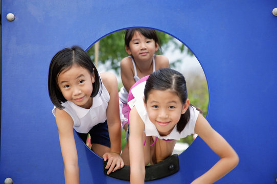 Girls In Playground, Climbing Through A Hole