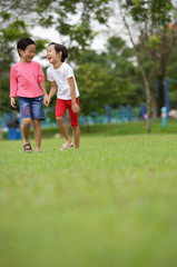 Obraz premium Two girls walking in park, laughing