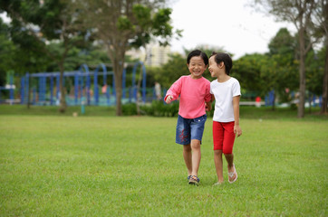 Young girls walking on grass, in park