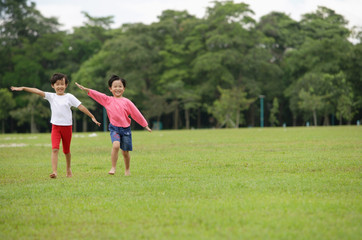 Two girls running on grass, side by side