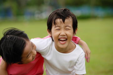 Two girls with arms around each other, laughing