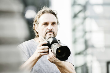Fotograf mit seiner Kamera auf Motivsuche in der stadt