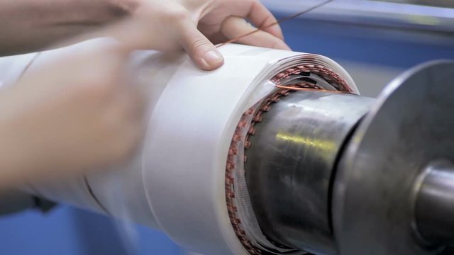 Transformer, engine production. Worker operates with electric cooper wires, winding of the transformer. HD.