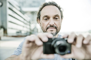 Fototapeta na wymiar Mann fotografiert mit seiner digitalen Kompaktkamera
