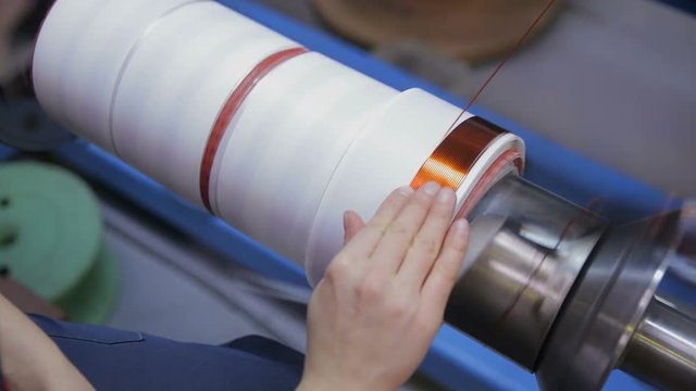 Worker operates with electric cooper wires, winding of the transformer. HD.