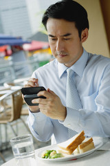 Businessman in cafe, using PDA