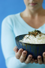Woman holding bowl of rice, selective focus