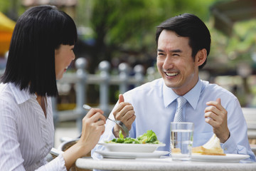 Businesswoman and businessman at outdoor cafe, having lunch