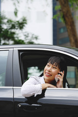 Businesswoman in car using mobile phone